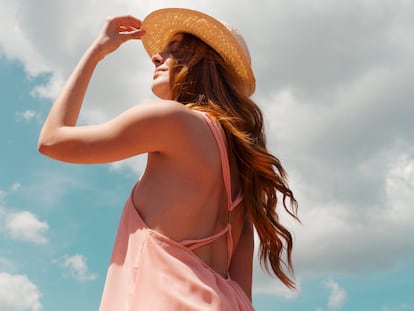 Chica tomando en sol con un sombrero.