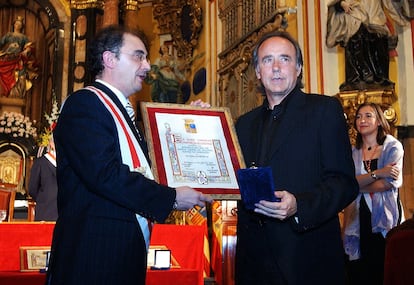 El cantante Joan Manuel Serrat recibe de manos del titular de la Diputación de Zaragoza, Javier Lambán, la medalla de oro de Santa Isabel de Portugal, durante un acto en la Iglesia de Santa Isabel de Portugal, el 6 de julio de 2004.