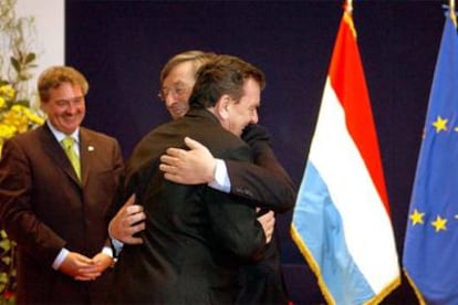 El primer ministro de Luxemburgo, Jean-Claude Juncker, abraza al canciller alemán, Gerhard Schröder, antes de comenzar la reunión de ayer.