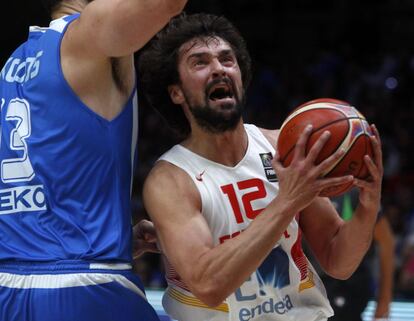 Sergio Llull (d) entrando a canasta mientras le defiende Kostas Koufos.