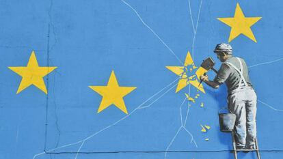 Un mural del artista británico Banksy, que muestra a un trabajador cortando una de las estrellas en una bandera temática de la Unión Europea (UE), en Dover, sureste de Inglaterra.