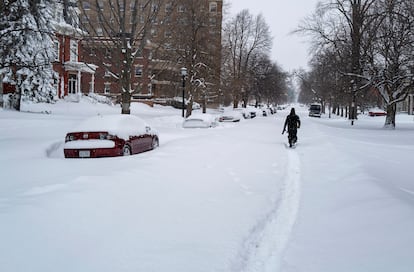 Daniel Shafer, habitante de Búfalo, camina a lo largo de una calle cubierta bajo la nieve.