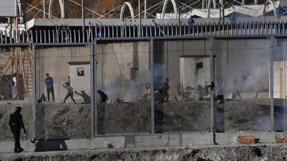 Varios ciudadanos marroquíes lanzan piedras en la frontera del Tarajal, en Ceuta, este miércoles.