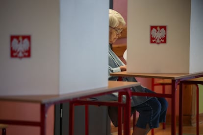 Una mujer sentada en una cabina de votación durante las elecciones europeas en Varsovia (Polonia), este domingo. 