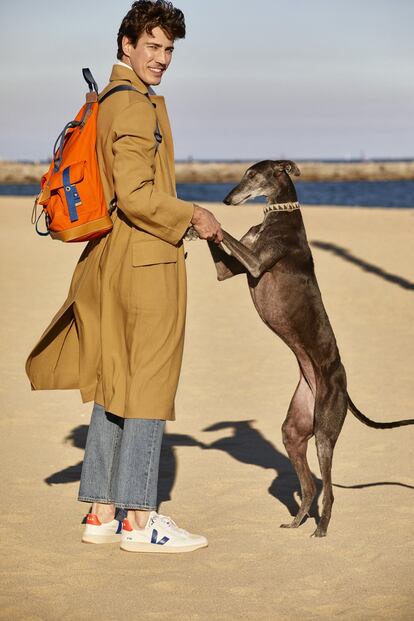 <b>Escapadas a la playa</b><br> Suele ir a pasear o correr por la playa de Barcelona con su galga <i>Tiny</i>. “Solo si no hay gente, claro”. En la foto, con gabardina de crepé y algodón de Salvatore Ferragamo, vaqueros de Levi’s para Zalando y mochila en canvas naranja con detalles en piel de la colección Eye Nature, de Loewe.<br> <br> —<br><p> El modelo Oriol Elcacho se levanta a las siete de la mañana. Sale a correr con su galga, <i>Tiny</i>. Vuelve a casa, se arregla y responde a unos cuantos correos electrónicos. Luego va a la reunión de trabajo o a la sesión de fotos que toque y encuentra como sea un hueco para el deporte (correr, nadar o montar en bici), sus amigos y su pareja. Esta rutina diaria es un lujo para el catalán, acostumbrado hasta hace poco a la vida nómada de los modelos, con agendas imprevisibles, largos viajes, campañas comerciales y eventos ineludibles. Una aventura que comparte desde 2006 con su pareja, la también modelo Davinia Pelegrí, y que ha desembocado en esta vida más tranquila en Barcelona, con planes de mudarse a las afueras. “Después de tantos años instalados en ciudades como Nueva York o Milán, apetece disfrutar de la calma y la naturaleza”, cuenta. Los fines de semana, la pareja hace senderismo, siempre acompañada de <i>Tiny</i>. “La adoptamos en 2017. Llegó con heridas físicas y psicológicas que han tardado en cicatrizar”. A Elcacho y Pelegrí siempre les habían gustado los animales (“De hecho, Davinia estudió Ciencias Medioambientales y eso nos ha acercado mucho a la naturaleza”), pero no habían podido cuidar de uno antes. </p> <br><p> Elcacho tenía apenas 20 años cuando un cazatalentos le fichó y cambió sus estudios de Comercio Internacional por la moda. La decisión parecía arriesgada en una época en la que pocos conseguían una trayectoria internacional, pero a él le fue más que bien. Ha sido imagen de Bulgari, Custo, Cavalli, Galliano, Polo Ralph Lauren y Valentino. Ahora, a punto de cumplir 40 años y consciente de lo efímero de una profesión en la que el físico determina la duración de su carrera, ha empezado a buscar nuevos campos de acción. “La moda sigue siendo un porcentaje alto de mi trabajo, pero ahora estoy metido en varios proyectos empresariales”. El primero arrancó en 2015: la creación del vino Traca i Mocador con su viejo compañero de colegio Josep Borràs. El segundo, hace dos años, con la firma de sastrería B Corner Madrid. “Mi labor se centra en la parte creativa y comercial. Llevo media vida protagonizando campañas con las que alguien quería contar una historia. He trabajado mano a mano con las figuras más relevantes de esta industria, como Ralph Lauren, y en este sector desarrollas buen ojo estético. Ahora aplico todo lo que aprendí en estos 20 años de profesión”. Su ajetreado día a día se parece hoy al de muchos hombres y no tanto al de otros modelos. A diferencia de la mayoría, no vive pegado a su <i>instagram</i>. Tiene perfil, claro. Y más de 15.000 seguidores. Pero su cuenta es privada. “Las redes sociales son un arma de doble filo. Creo que la sobreexposición puede perjudicarnos, por eso la privacidad importa tanto”.</p> <br>Texto de Sara Cuesta Torrado<br><br> —<br> Asistente de estilismo: Almudena Cañedo. Maquillaje y peluquería: Paco Garrigues (de Kasteel) para Sisley y Bumble and Bumble. Producción: Lighthouse. Agradecimientos: hotel The Barcelona Edition y Noak Room Furniture Store.