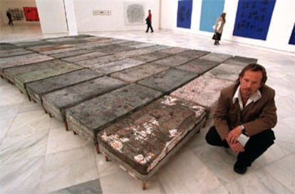 El artista Guillermo Kuitca, ayer en el Palacio de Velázquez del Retiro, ante su instalación <i>Sin título,</i> de 1992, acrílico sobre 52 colchones y patas de madera.
