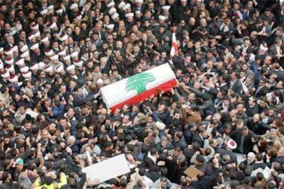 El féretro de Hariri, envuelto en una bandera libanesa, es transportado a través de una multitud, ayer en Beirut.