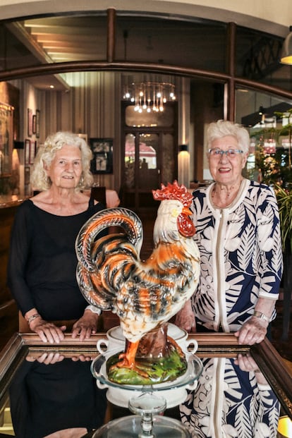 Paquita (dcha.) y Lolita Rexach posan junto al célebre gallo que preside la entrada al Hispania.