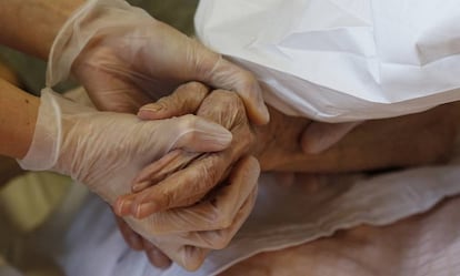 Una doctora sostiene la mano de una anciana mientras le inoculan la vacuna de la covid-19 en Roma, Italia, el 13 de enero de 2021.  