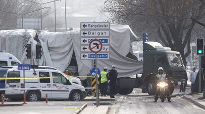 Policías monta guardia mientras trabajadores retiran los restos del autobús donde se produjo una explosión la noche anterior en Ankara (Turquía), 18 de febrero de 2016.