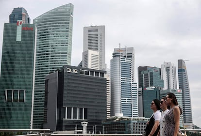 Turistas chinos caminan frente al distrito financiero de Singapur, que se mantiene un año más en el cuarto puesto de la lista de las ciudades más caras para expatriados.