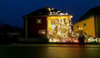 Una pareja observa la decoración navideña de una casa iluminada con unas 67.000 bombillas en Völklingen (Alemania), el 4 de diciembre de 2017.