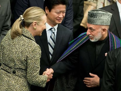 La secretaria de Estado de EE UU, Hillary Clinton, saluda al presidente afgano, Hamid Karzai, en presencia del ministro de Exteriores de Jap&oacute;n, pa&iacute;s anfitri&oacute;n de la Conferencia de donantes, hoy en Tokio. 