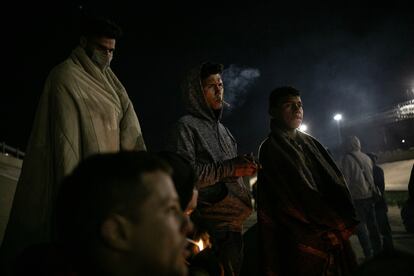 Migrantes se protegen de las bajas temperaturas junto a una fogata improvisada a unos pasos del río Bravo, en México. 