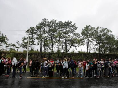 Migrantes hondureños hacen cola para cruzar a Guatemala en su camino a EE UU. 