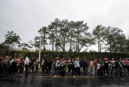 Migrantes hondureños hacen cola para cruzar a Guatemala en su camino a EE UU. 