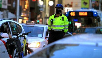 Un agente de movilidad vigila el tr&aacute;fico durante uno de los d&iacute;as de alta contaminaci&oacute;n en Madrid.