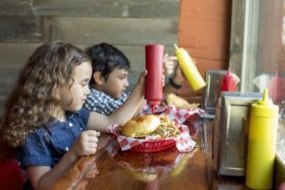 Niños comiendo la siempre eficaz hamburguesa.