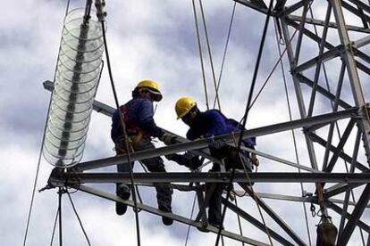 Dos operarios de Endesa trabajan en una torre de alta tensión para tratar de devolver la electricidad a Tenerife.