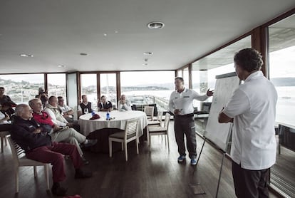 Reunión de las tripulaciones antes de las regatas en el Real Club Náutico de Sanxenxo, atendiendo a las indicaciones de Pedro Campos (en el centro). A la izquierda de la imagen, con pantalón rojo, José Cusí, armador de la saga de veleros 'Bribón' que ha patroneado Juan Carlos I.