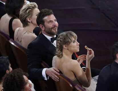 Bradley Cooper, nomiando a mejor actor de reparto por su papel en American Hustle, junto a su novia Suki Waterhouse comiendo pizza