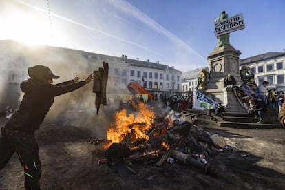 Agricultores alimentan una hoguera en el centro de Bruselas durante la protesta, este jueves.