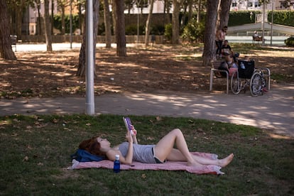 Una dona llegeix en un parc públic de Barcelona