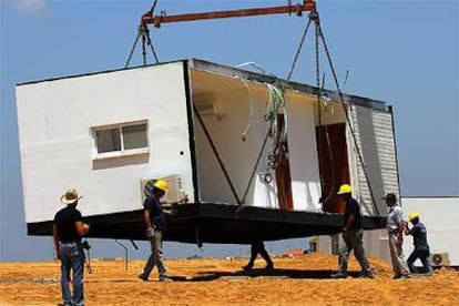 Trabajadores israelíes colocan una casa prefabricada prevista para la reubicación de colonos de Gaza.