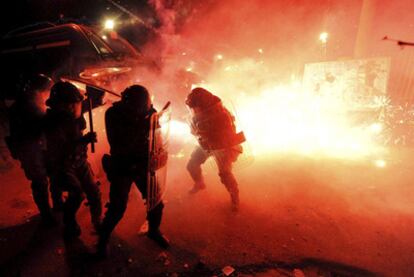 Policías italianos huyen de los petardos arrojados por los vecinos que viven junto al vertedero de Terzigno.