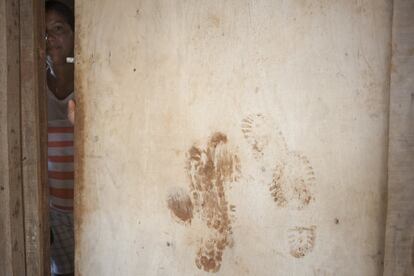Una mujer campesina de Guahory, distrito de Tembiapora, departamento de Caaguazú (Paraguay), muestra las marcas dejadas por las botas policiales en la puerta de su casa.