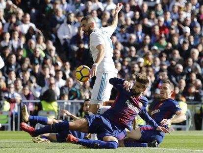 El jugador francés del Real Madrid Karim Bencema, y los jugadores del Barcelona Gerard Piqué,frente, y Thomas Vermaelen.