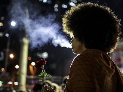 Una mujer sostiene una flor en una manifestación política en Rio de Janeiro