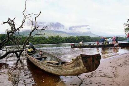 Estas canoas, llamadas curiara por los indios pemones, conducen a los turistas hasta el Salto del Ángel. Entre la niebla, al fondo, la silueta de los tepuyes.