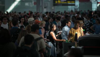 Viatgers passant el primer control de seguretat després de fer cua al Prat.