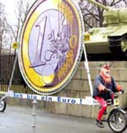 Un berlinés disfrazado de diablo monta un bicicleta que porta un cartel en el que se lee:¡ Soy un euro!