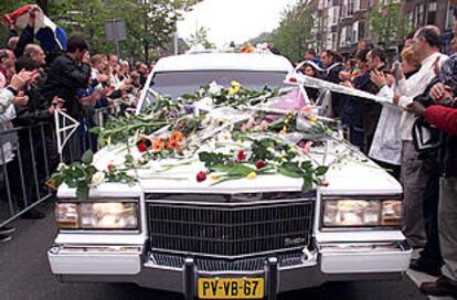 Simpatizantes de Pim Fortuyn depositan flores sobre el coche fúnebre a su paso por las calles de Rotterdam.