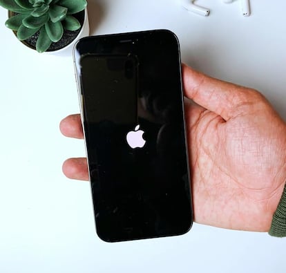 iPhone con el logo de Apple en una mano