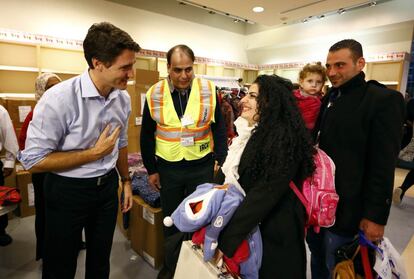 Syrian refugees are greeted by Canada's Prime Minister Justin Trudeau (L) on their arrival from Beirut at the Toronto Pearson International Airport in Mississauga, Ontario, Canada December 11, 2015. After months of promises and weeks of preparation, the first Canadian government planeload of Syrian refugees landed in Toronto on Thursday, aboard a military aircraft met by Prime Minister Justin Trudeau.  REUTERS/Mark Blinch TPX IMAGES OF THE DAY