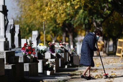 Una mujer visita la tumba de sus familiares en el cementerio madrileño de la Almudena.