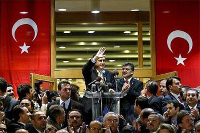Erdogan saluda ante de comenzar la rueda de prensa que dio ayer tras su llegada al aeropuerto de Ankara. A su lado, el ministro de Exteriores, Abdulá Gül.