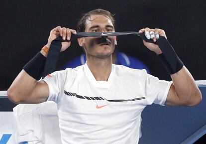 El tenista español Rafael Nadal se coloca una cinta en la cabeza.