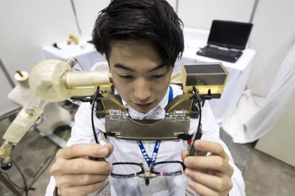 Un estudiante se coloca unas gafas como parte de la demostración de un robot de asistencia en la exposición del World Robot Summit en Tokio (Japón).