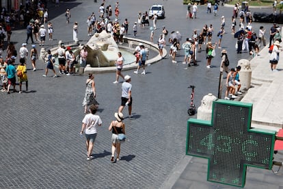 People spend time near Fontana della Barcaccia, at the Piazza di Spagna, during a heatwave across Italy