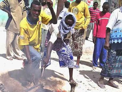 Unos somalíes golpean el cadáver quemado de un soldado gubernamental ayer en Mogadiscio.