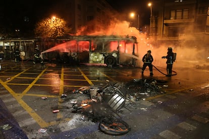 Los bomberos apagan las llamas de un autobús en llamas durante las protestas del 18 de octubre de 2019, tras el aumento de las tarifas en el transporte público.