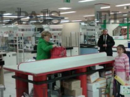 Angela Merkel, colocando su compra en una cesta.
