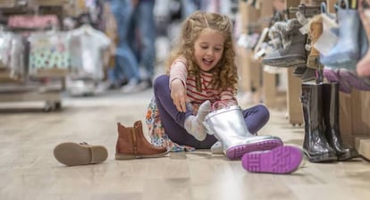 Una niña se prueba zapatos en una tienda. 