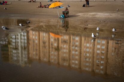 People sunbathe on a beach in Cadiz, Spain, Monday, June 13, 2022. Spain's weather service says a mass of hot air from north Africa is triggering the country's first major heat wave of the year with temperatures expected to rise to 43 degrees Celsius (109 degrees Fahrenheit) in certain areas. (AP Photo/Emilio Morenatti)