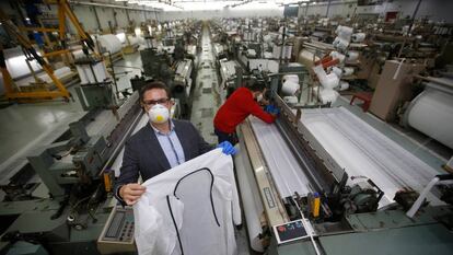 Abel Ortiz muestras una de las batas que ha logrado fabricar la cadena de empresas que ha creado.