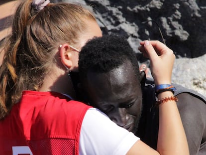 Abdou, senegalés de 27 años, se abraza a la voluntaria de la Cruz Roja Luna Reyes, el pasado martes en la playa del Tarajal (Ceuta).